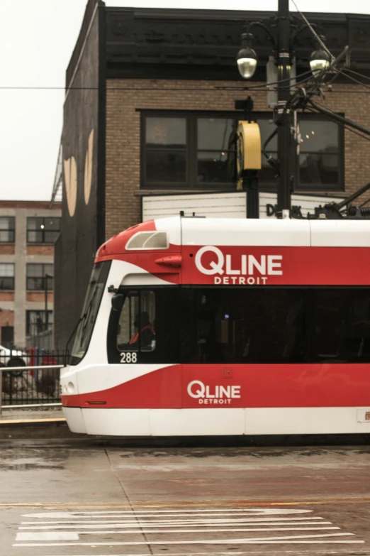 a red and white tram is at a station