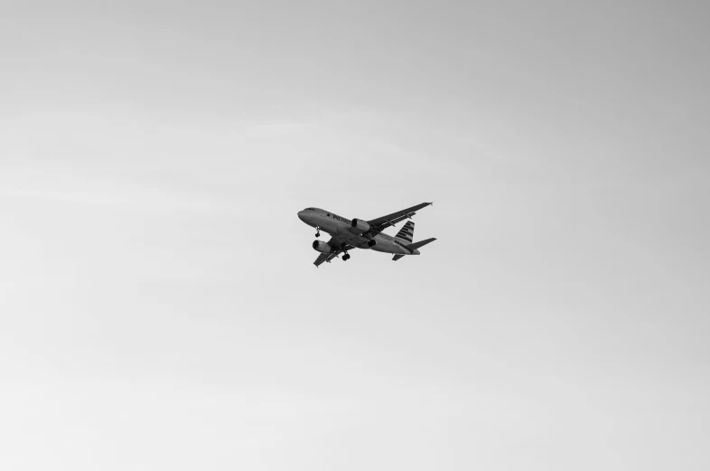 an airplane flying in the air on a cloudy day
