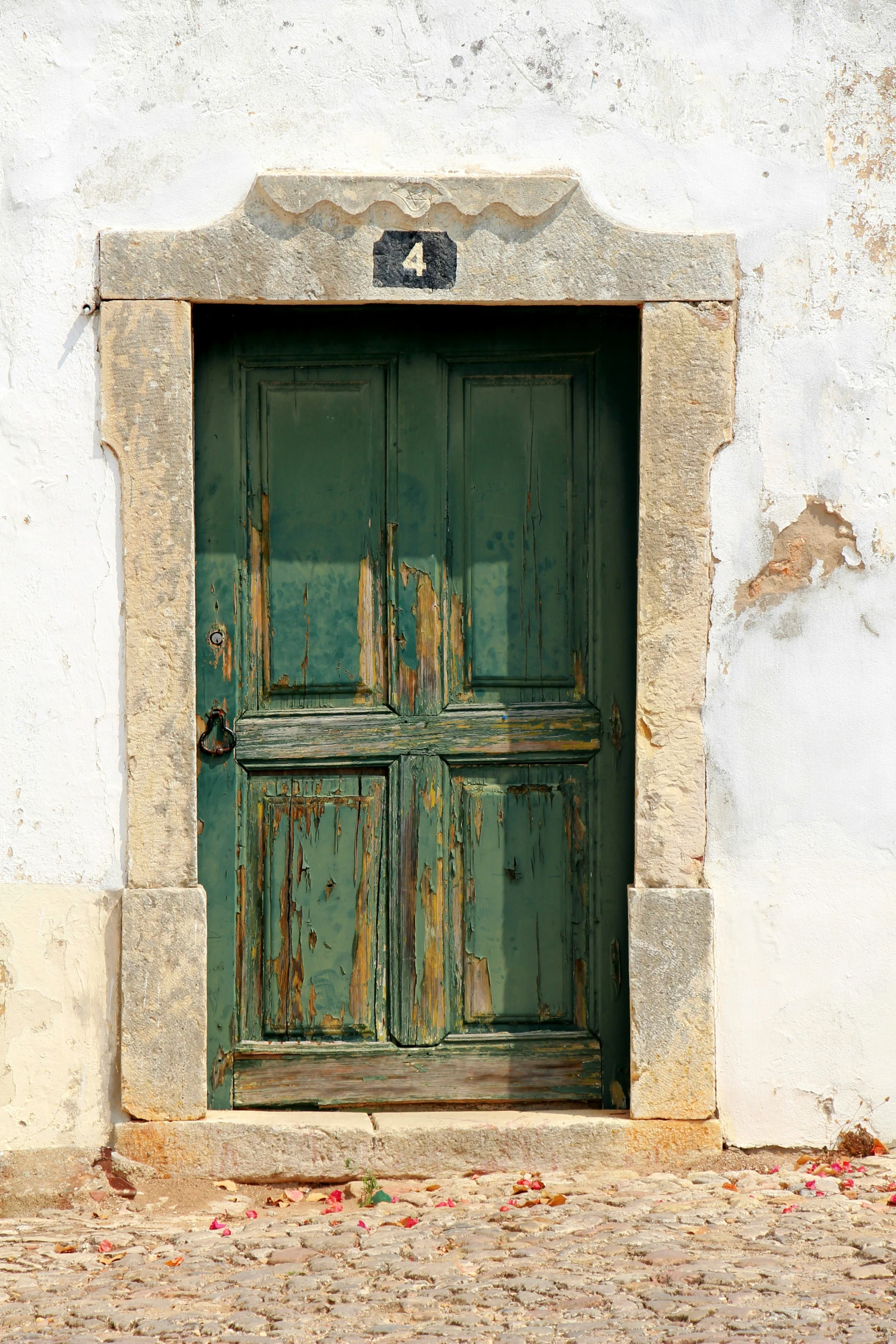 a doorway with a rusty handle on a white building