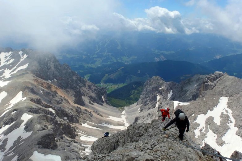 a couple of people climbing up a steep hill