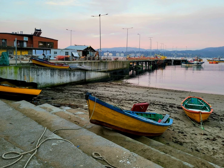 small boats docked at a pier on the shore