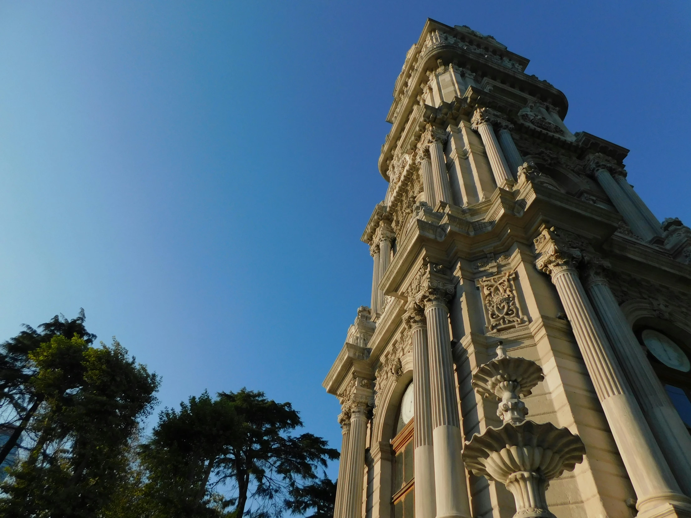 a large white clock tower against a blue sky