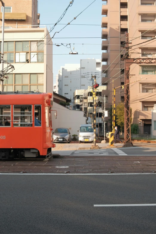 an orange bus going down the middle of the street