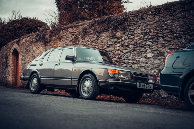 two cars parked near a brick wall in an old world setting