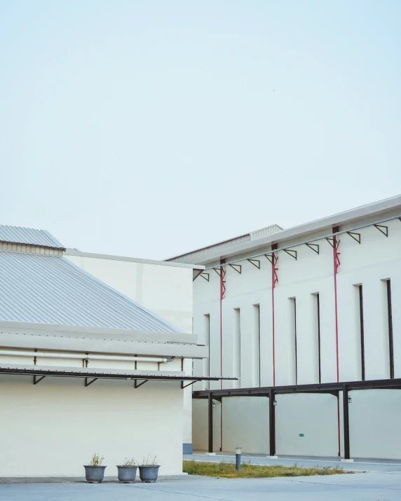 a white building with two long red strings hanging from the roof