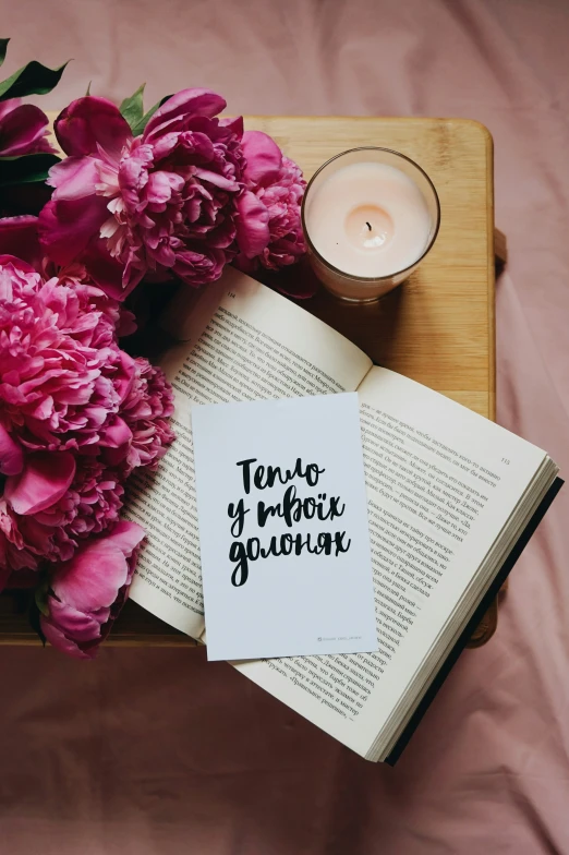 a book sitting on top of a table with some flowers