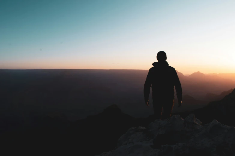 a lone person standing on top of a hill