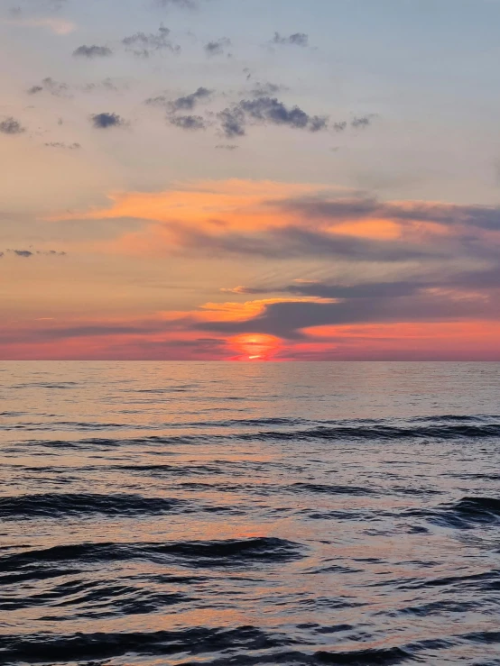 a po taken on a beach with a cloudy sunset