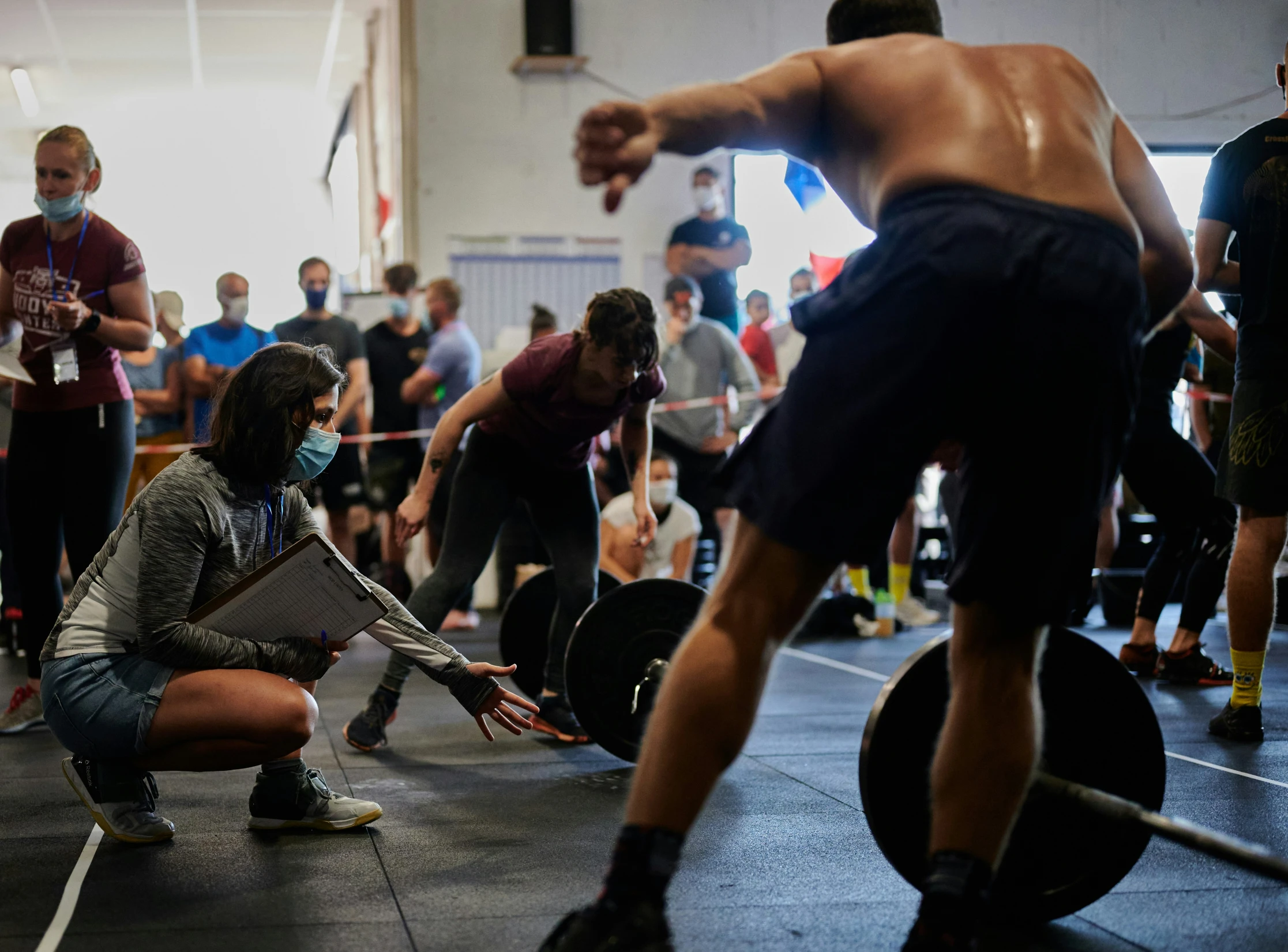 an athlete squats while holding her weight during a competition