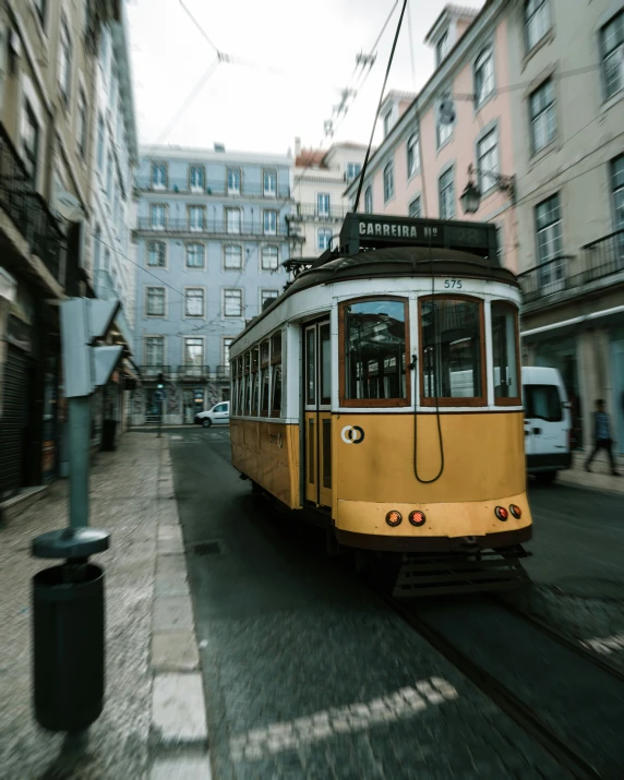 an old tram drives down the street next to buildings