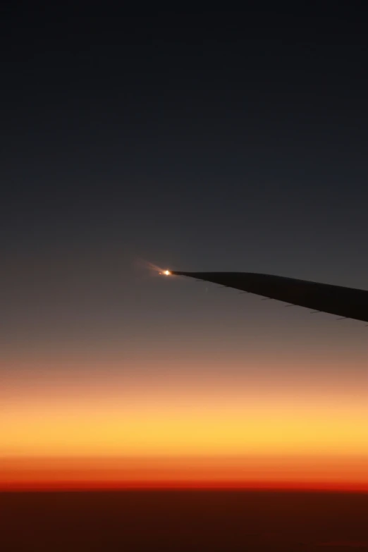 the view from an airplane shows the tail and sky at night