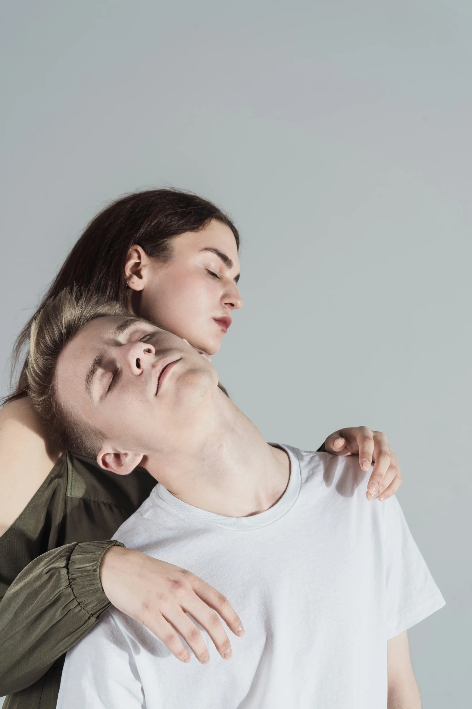 two people pose for the camera while one of them is covering his face