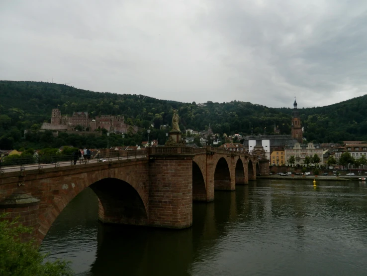 a long bridge over water with a clock on the top of it