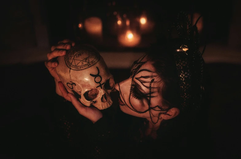 a woman holding a half skull in her face