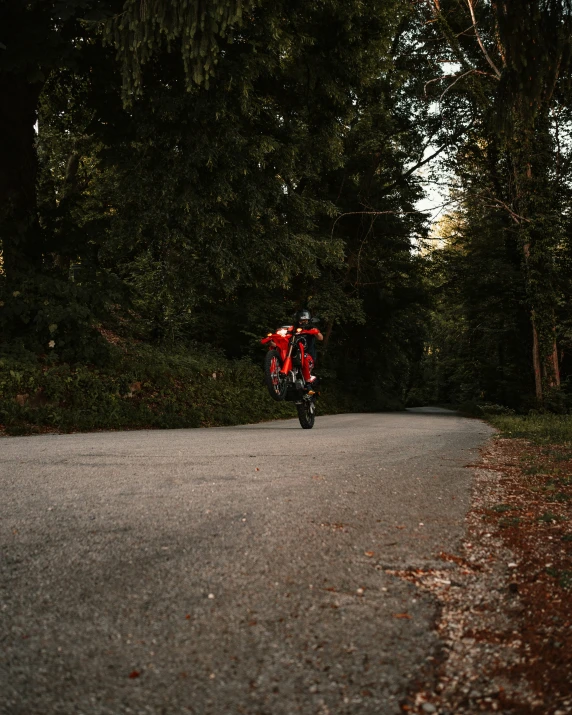 a man riding on the back of a motorcycle down a street