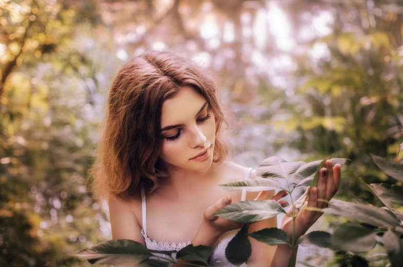 a woman is standing amongst many plants and trees