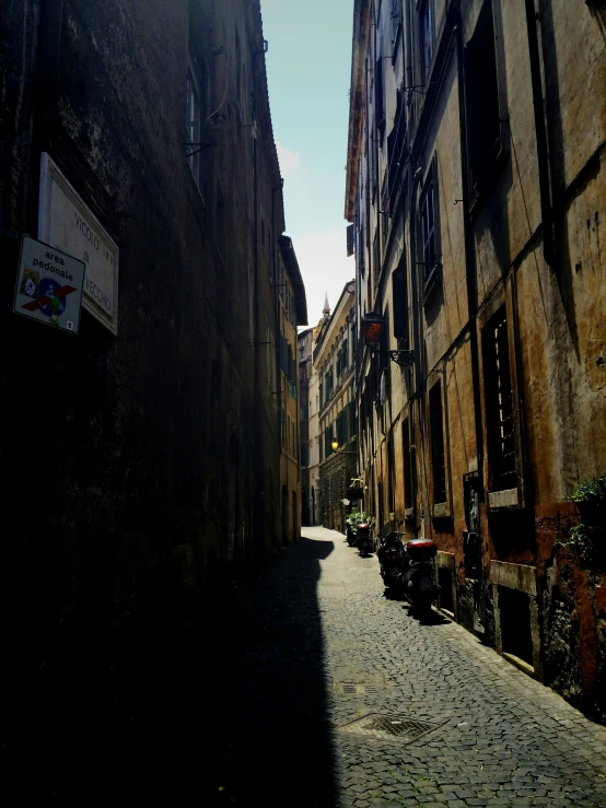 a narrow street in a city is shown with buildings