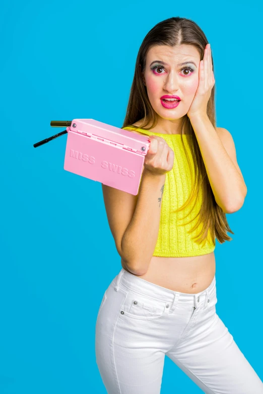 a woman is holding a pink case while making a funny face