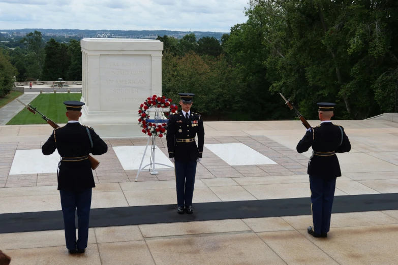 some military men are standing outside with wreaths