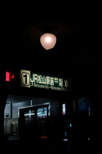 an asian business with sign above door at night