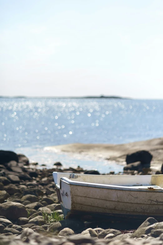 a small boat on the beach near some water