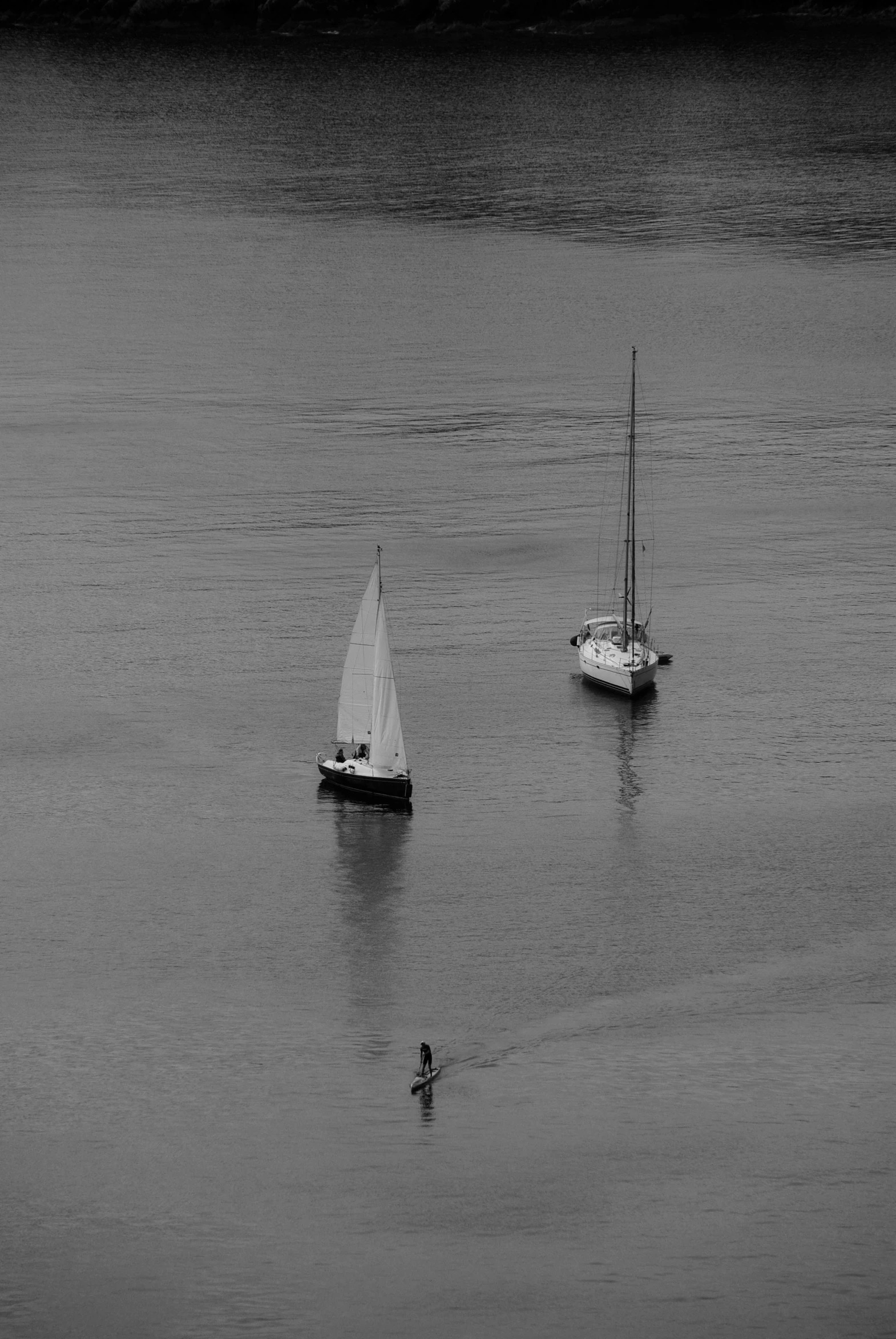 two small boats on calm water and one in a smaller boat