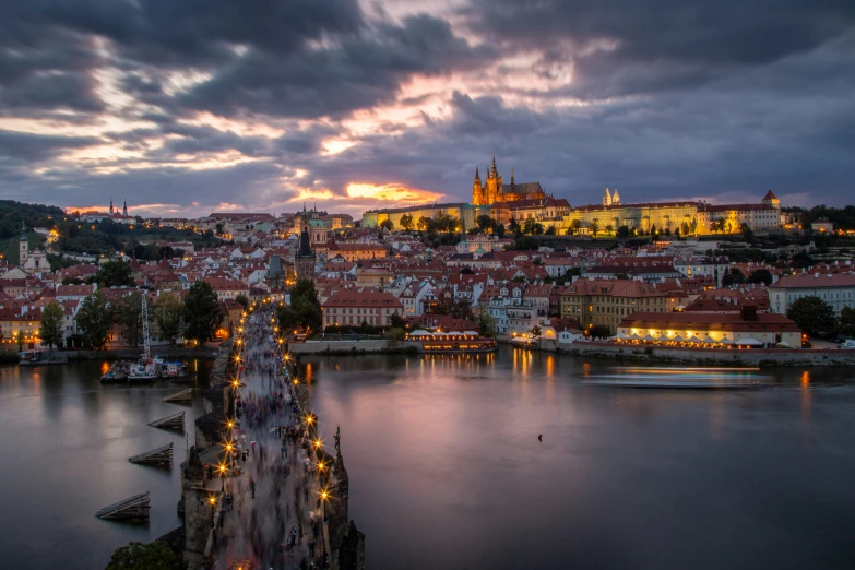 dusk view of city with water and castle with dark clouds