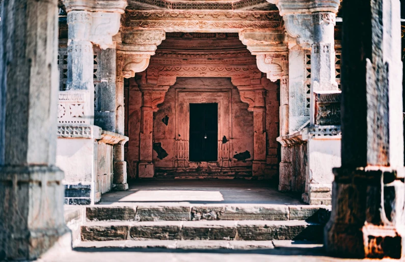 an old indian style building with pillars and doors