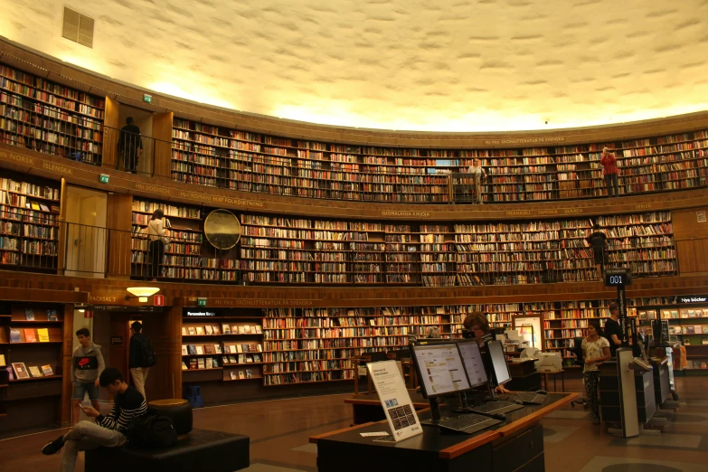people looking at various books on large bookshelves