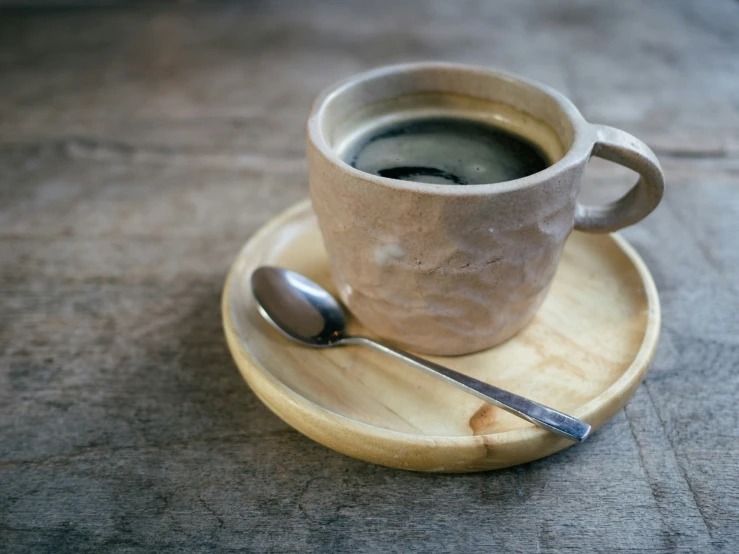 a cup of coffee next to a spoon