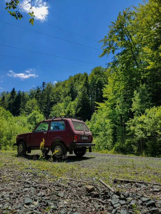 a small truck parked on a dirt road next to trees