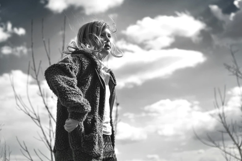 the woman is looking up at the sky and holding a skateboard