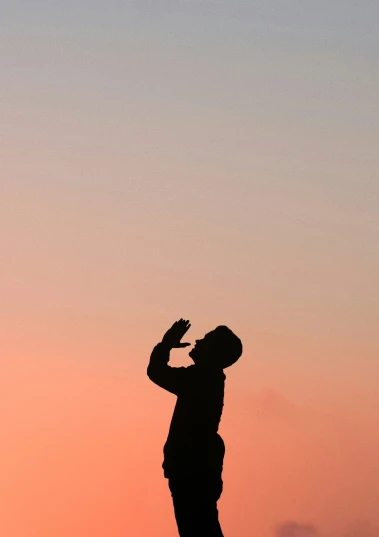silhouette of a man standing on the top of a mountain with a sky background