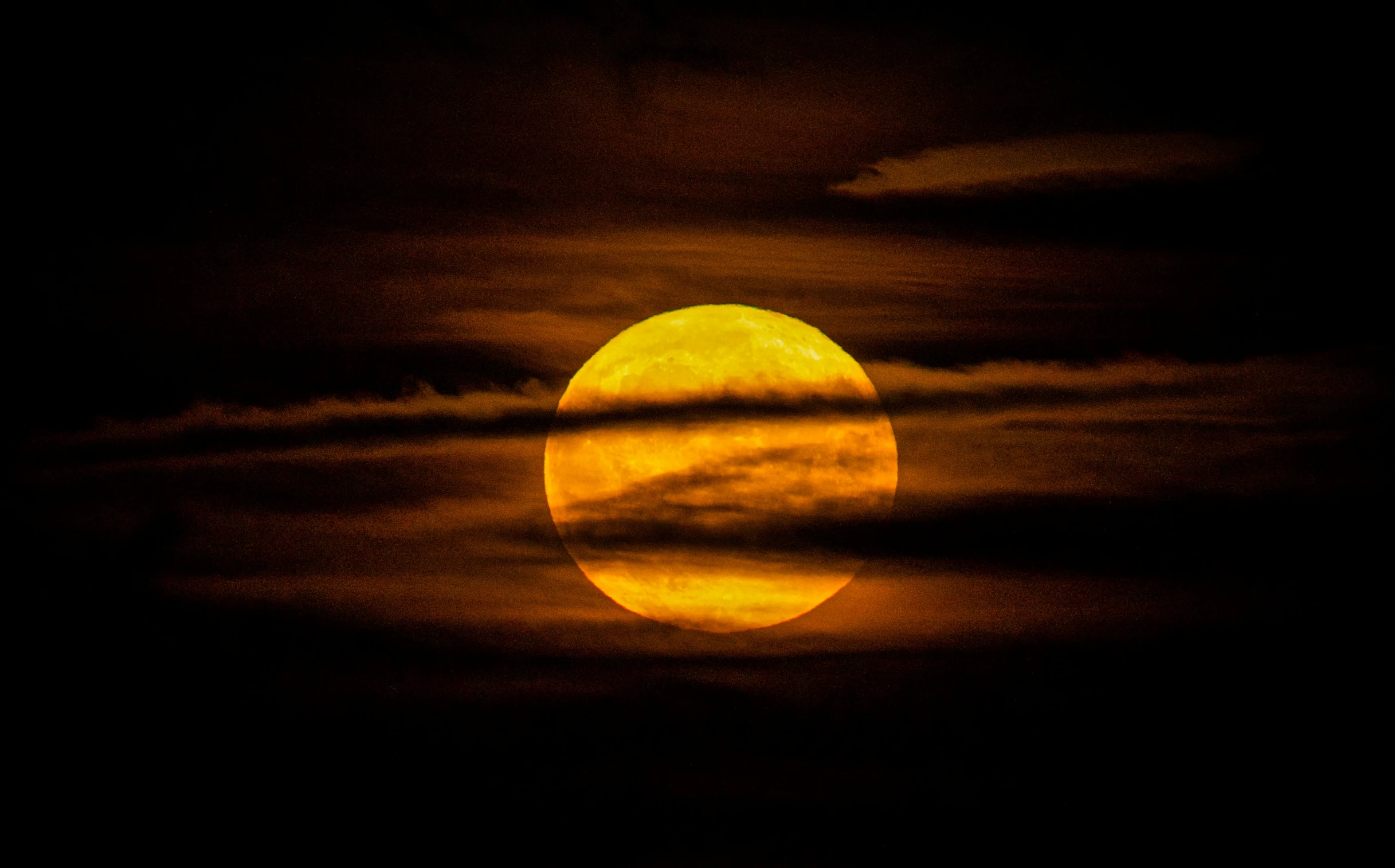 an image of a full moon seen through clouds