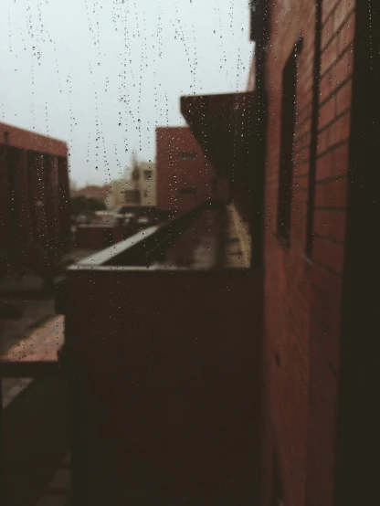 raindrops on a window, a brick building and buildings