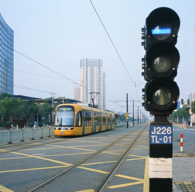 a yellow train on a track passing through the city