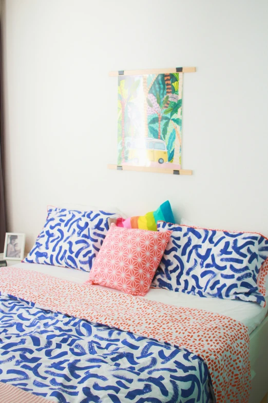 the bed has a bright comforter and colorful pillows