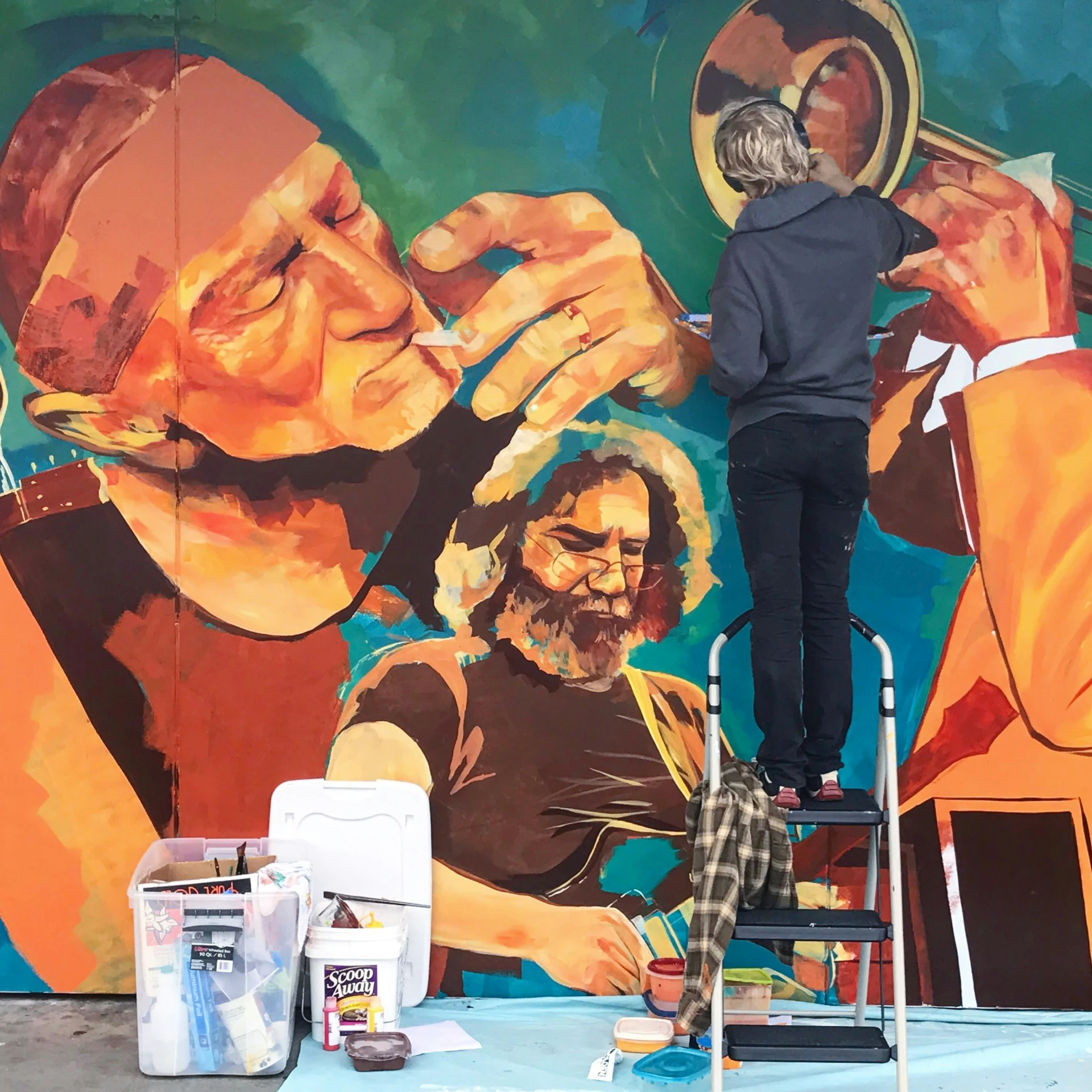 a man on a chair painting a wall