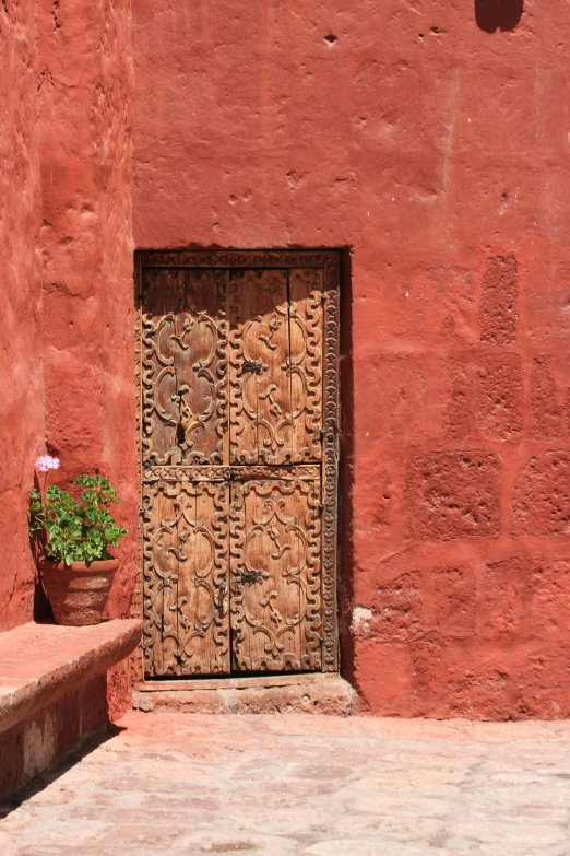 a red building with a flower plant in a flower pot