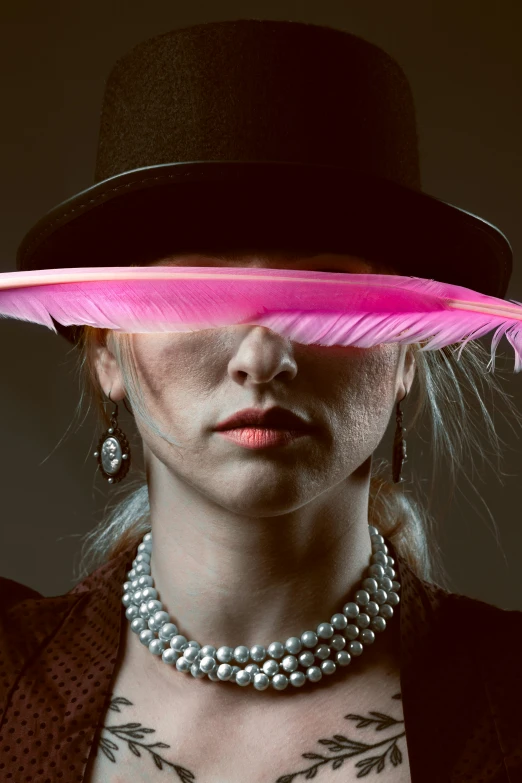 a woman wearing a pink hat and feather necklace