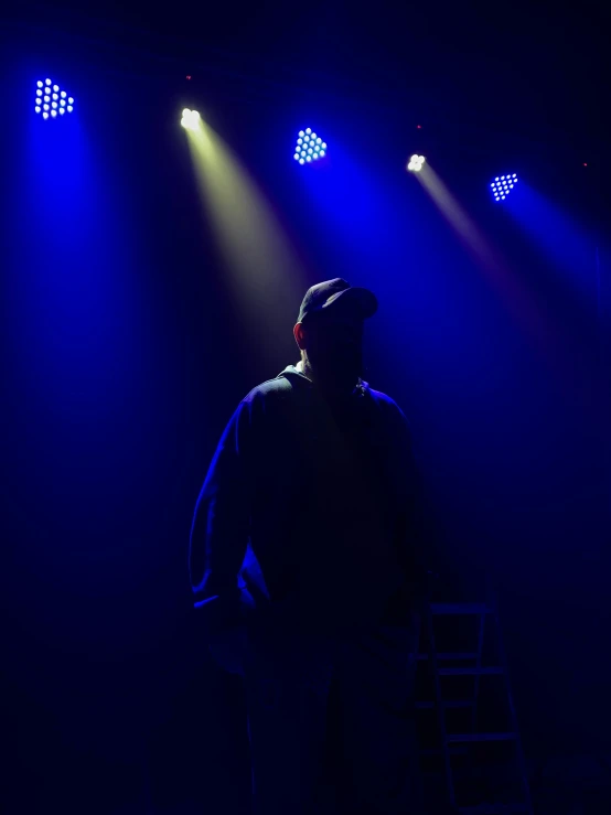 a person standing in front of blue lights