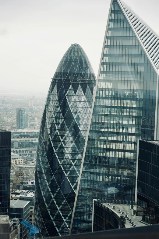 a tall, curved glass building stands near another skyscr