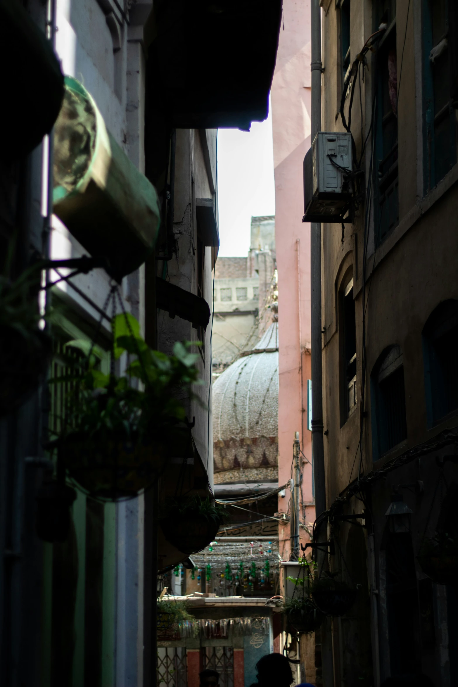 an alley way with buildings and a man standing on it