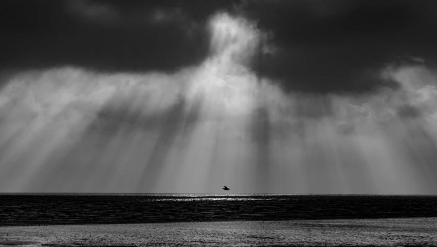 a person on a surfboard in the ocean under a cloudy sky