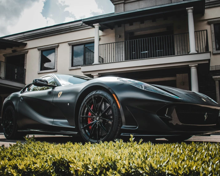 the unique lotus car is parked in front of a large house