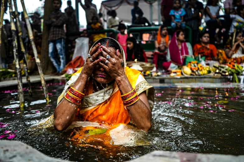 a person covered with water surrounded by flowers and other people