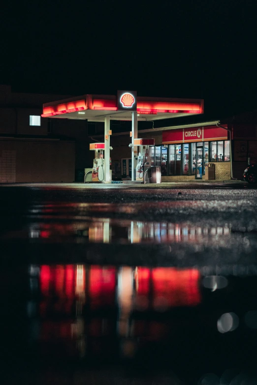 a dark night scene of a gas station with the lights on