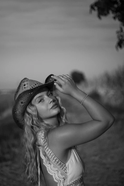 a woman in an open field with a hat