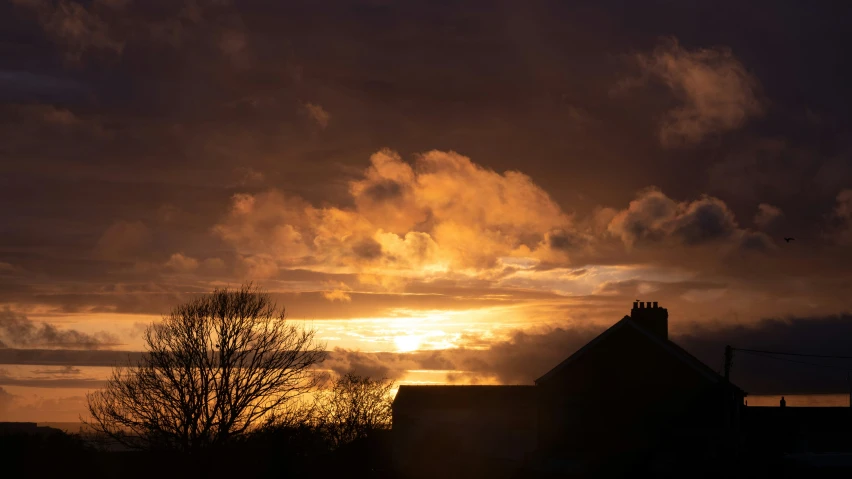 the sun is setting behind clouds in the distance