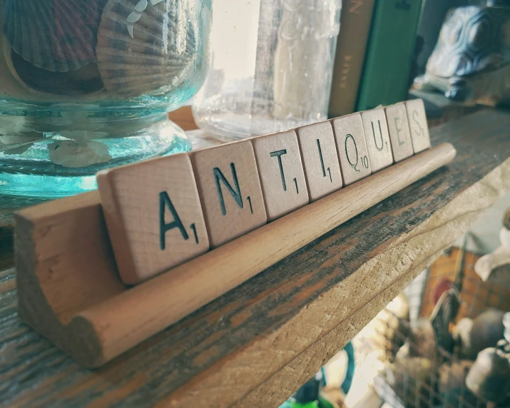 an unwritten block of wood with the words anttic up on it